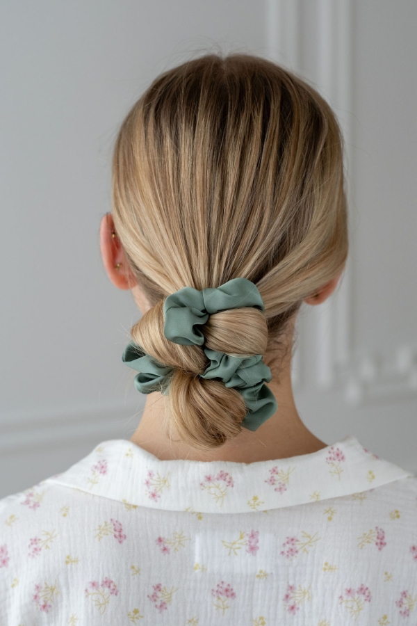 Zielona scrunchie z satyny prezentowana na koku na modelce